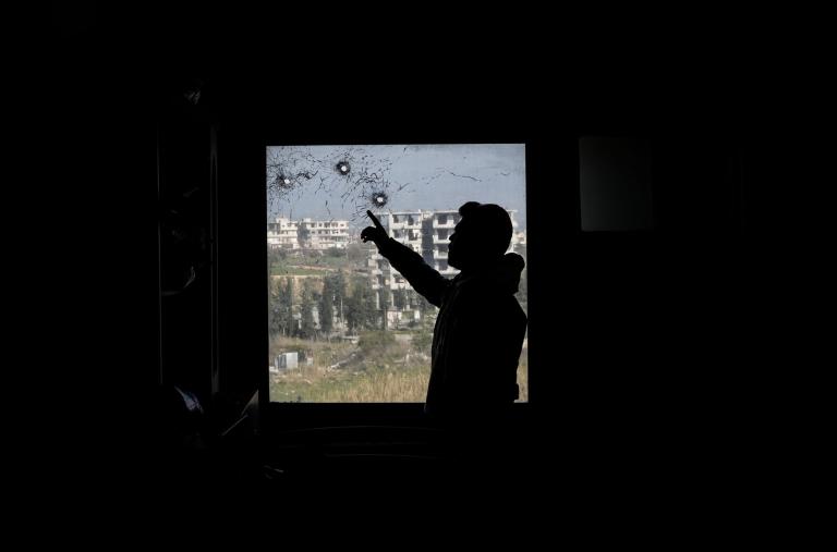 A Syrian man points at bullet holes in a window of a hospital in Jableh town, 25 km south of Latakia, following a spate of violence between Syrian security forces and insurgents loyal to deposed president Bashar al-Assad - source: Reuters