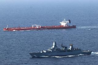 A commercial ship crosses the Bab al-Mandab Strait under the protection of a German navy frigate.