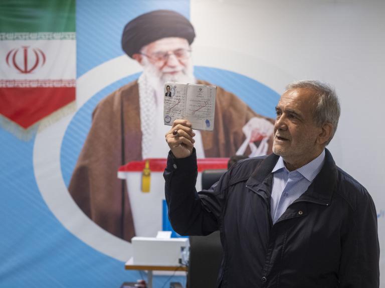 Iranian presidential candidate Masoud Pezeshkian poses in front of a poster of Iranian Supreme Leader Khamenei prior to Iran's 2024 presidential elections - source: Reuters