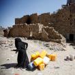 A Yemeni woman at a ruined building in Hodeidah