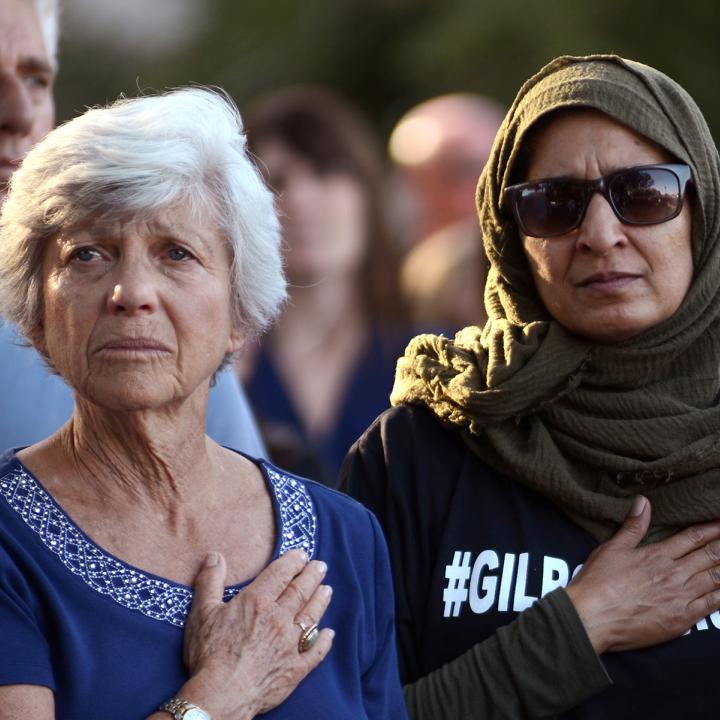 Women with hands on hearts, Gilroy, California, vigil