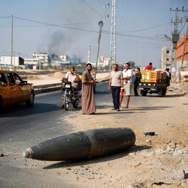 Palestinians view an unexploded Israeli shell in Gaza