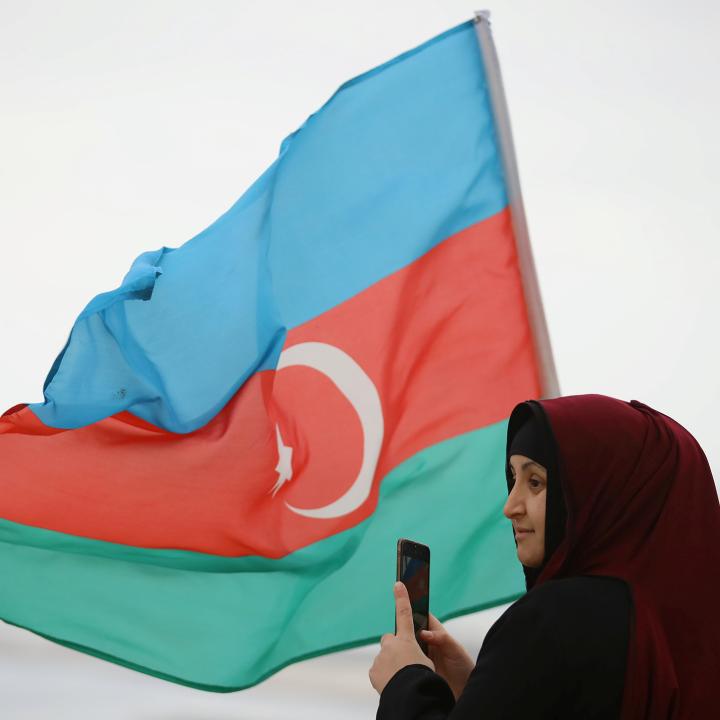 An Azeri woman with an Azerbaijan flag in the Nogorno-Karaback region of Armenia - source: Reuters