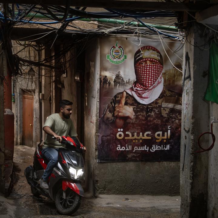 A man rides a scooter by a Hamas poster in a Palestinian refugee camp in Lebanon, May 18, 2024.