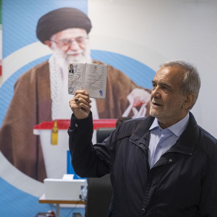 Iranian presidential candidate Masoud Pezeshkian poses in front of a poster of Iranian Supreme Leader Khamenei prior to Iran's 2024 presidential elections - source: Reuters