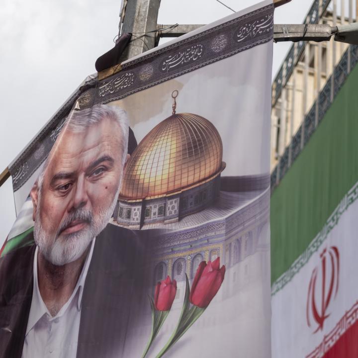 A poster depicts former Hamas leader Ismail Haniyeh alongside the Iranian flag in Tehran following Haniyeh's killing in Iran - source: Reuters