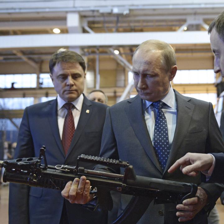 Russian president Vladimir Putin inspects a rifle while touring an arms factory in 2014 - source: Reuters