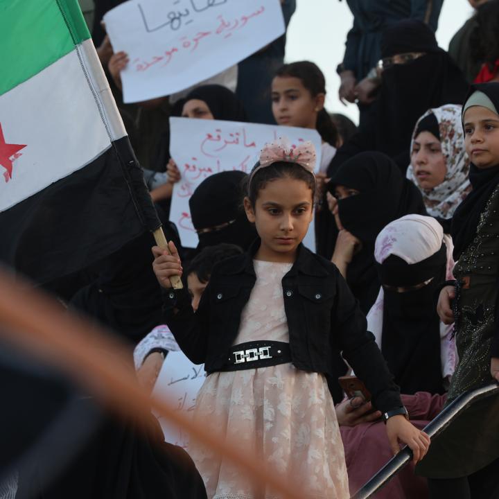 A Syrian girl waves a national flag during a protest in Idlib in support of demonstrations in Suwayda - source: Reuters 