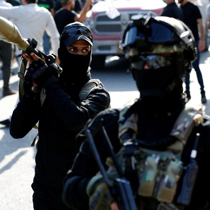 Armed members of the Iraqi Shiite militia Asaib Ahl al-Haq demonstrate at a funeral in Iraq - source: Reuters