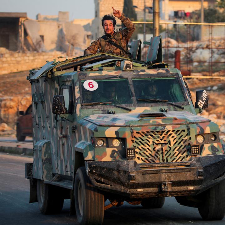 A rebel fighter belonging to the Islamist group Hayat Tahrir al-Sham gestures while riding a vehicle near Aleppo in November 2024 - source: Reuters