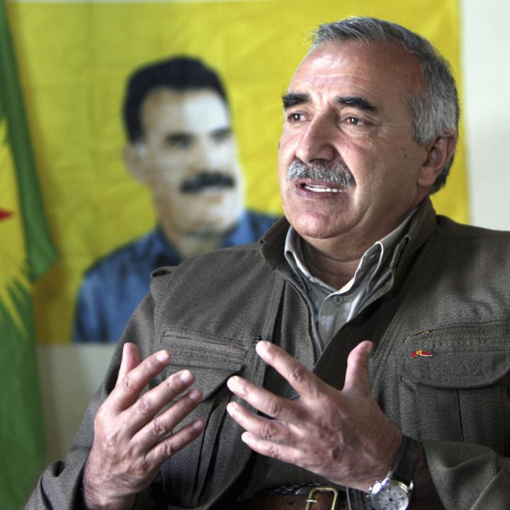 Karayilan, acting military commander of the PKK, speaks during an interview with Reuters at the Qandil mountains in Sulaimaniya in 2013, in front of a portrait of jailed PKK leader Abdullah Ocalan - source: Reuters