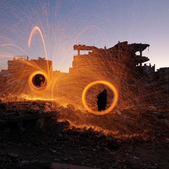 Photo showing Gaza residents spinning sparklers at the start of Ramadan, March 2025.