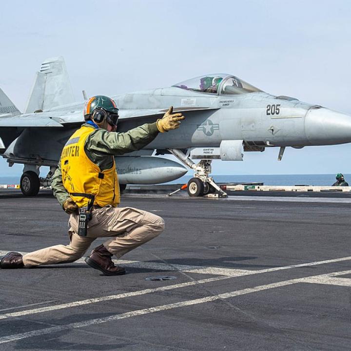 Photo of an F-18 fighter jet launching from a U.S. aircraft carrier.