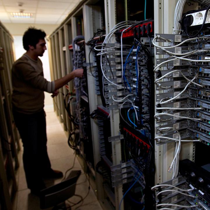 A man manipulates cables on a bank of internet data servers - source: Reuters