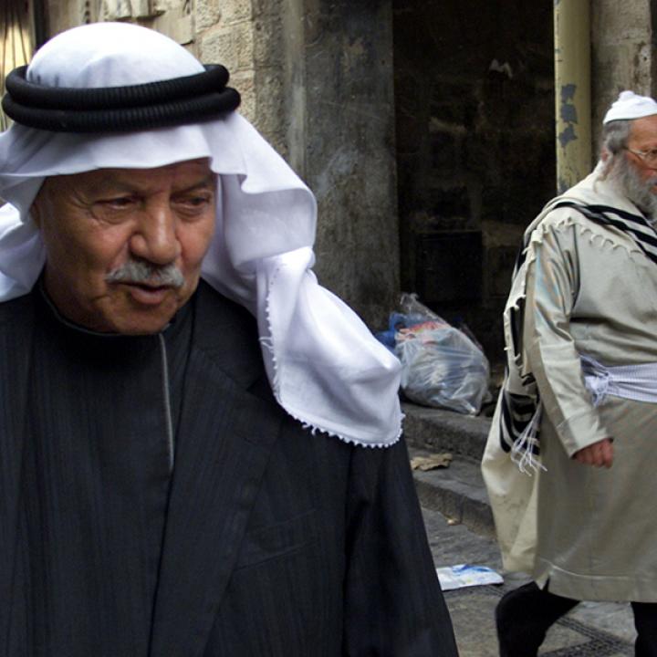 Close up of Palestinian men with keffiyeh walking in the street