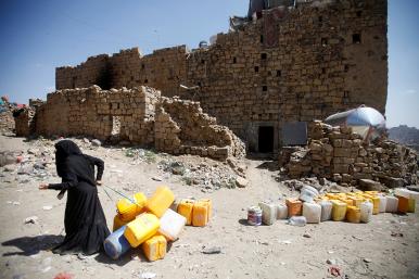 A Yemeni woman at a ruined building in Hodeidah