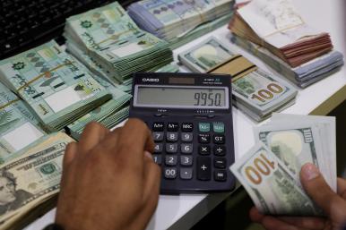 A Beirut money changer handles Lebanese pound and U.S. dollar notes - source: Reuters