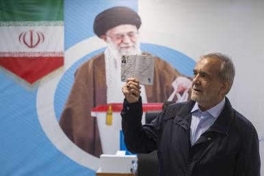 Iranian presidential candidate Masoud Pezeshkian poses in front of a poster of Iranian Supreme Leader Khamenei prior to Iran's 2024 presidential elections - source: Reuters