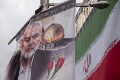 A poster depicts former Hamas leader Ismail Haniyeh alongside the Iranian flag in Tehran following Haniyeh's killing in Iran - source: Reuters