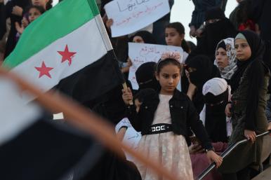 A Syrian girl waves a national flag during a protest in Idlib in support of demonstrations in Suwayda - source: Reuters 