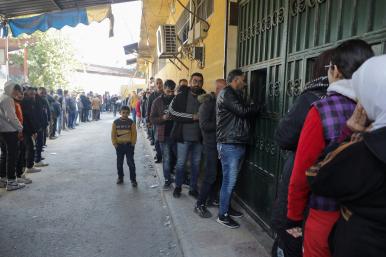 People queue for bread in rebel-occupied Aleppo in December 2024 - source: Reuters