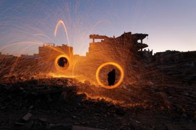 Photo showing Gaza residents spinning sparklers at the start of Ramadan, March 2025.