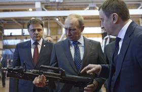 Russian president Vladimir Putin inspects a rifle while touring an arms factory in 2014 - source: Reuters