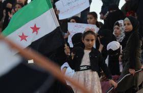 A Syrian girl waves a national flag during a protest in Idlib in support of demonstrations in Suwayda - source: Reuters 