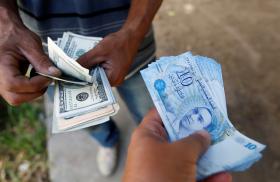 A Tunisian purchases dollars from a money-changer - source: Reuters